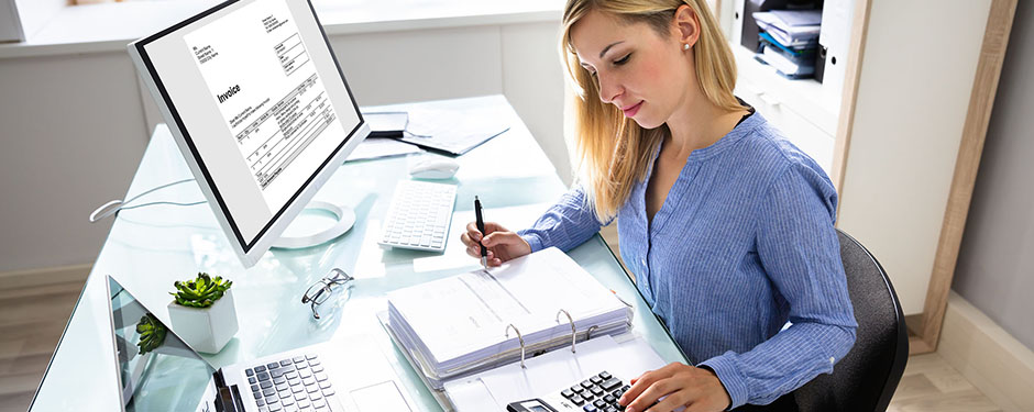 Young Businesswoman Calculating Bill In Office